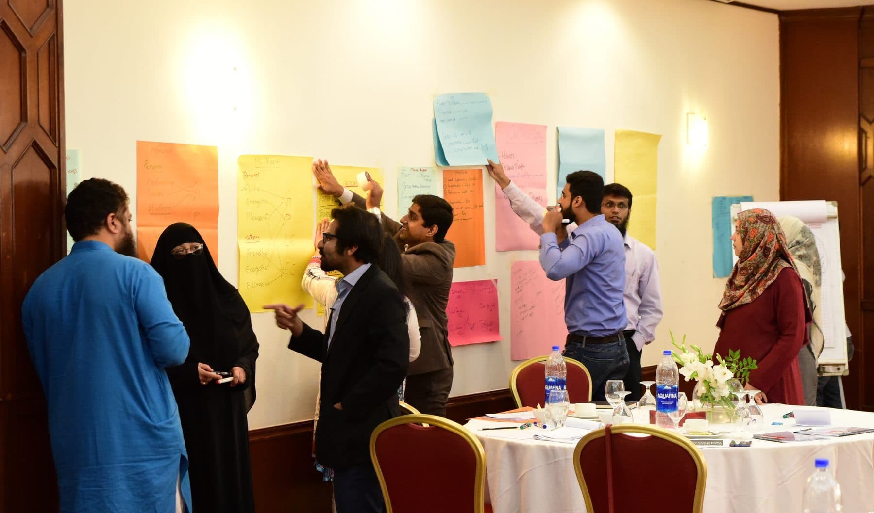 A turnshop group working across a wall of flip charts, mid-session