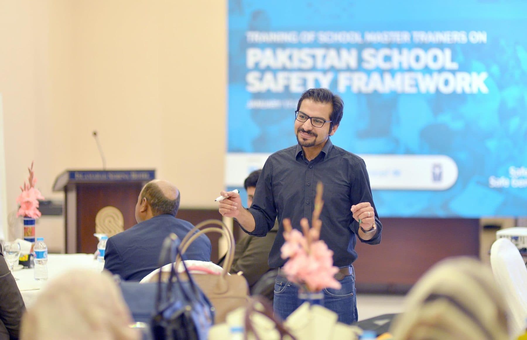 A Torque trainer mid-session in front of a Pakistan School Safety Framework banner