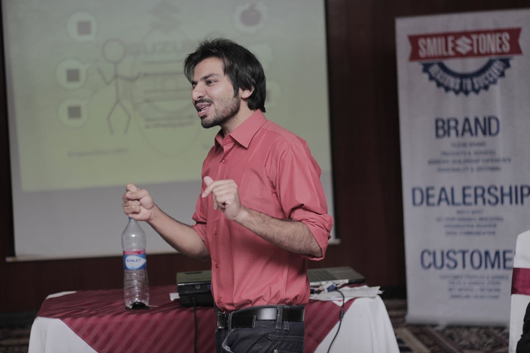A Smilestones session in progress, trainer mid-sentence beside a branded banner